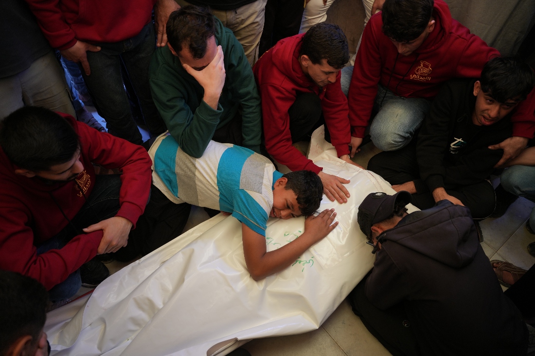 A Palestinian boy Baraa Heikal mourns over the body of his brother Fadi Heikal, who was killed in an Israeli strike, during his funeral at Nasser Hospital in Khan Younis, southern Gaza Strip. (AP)