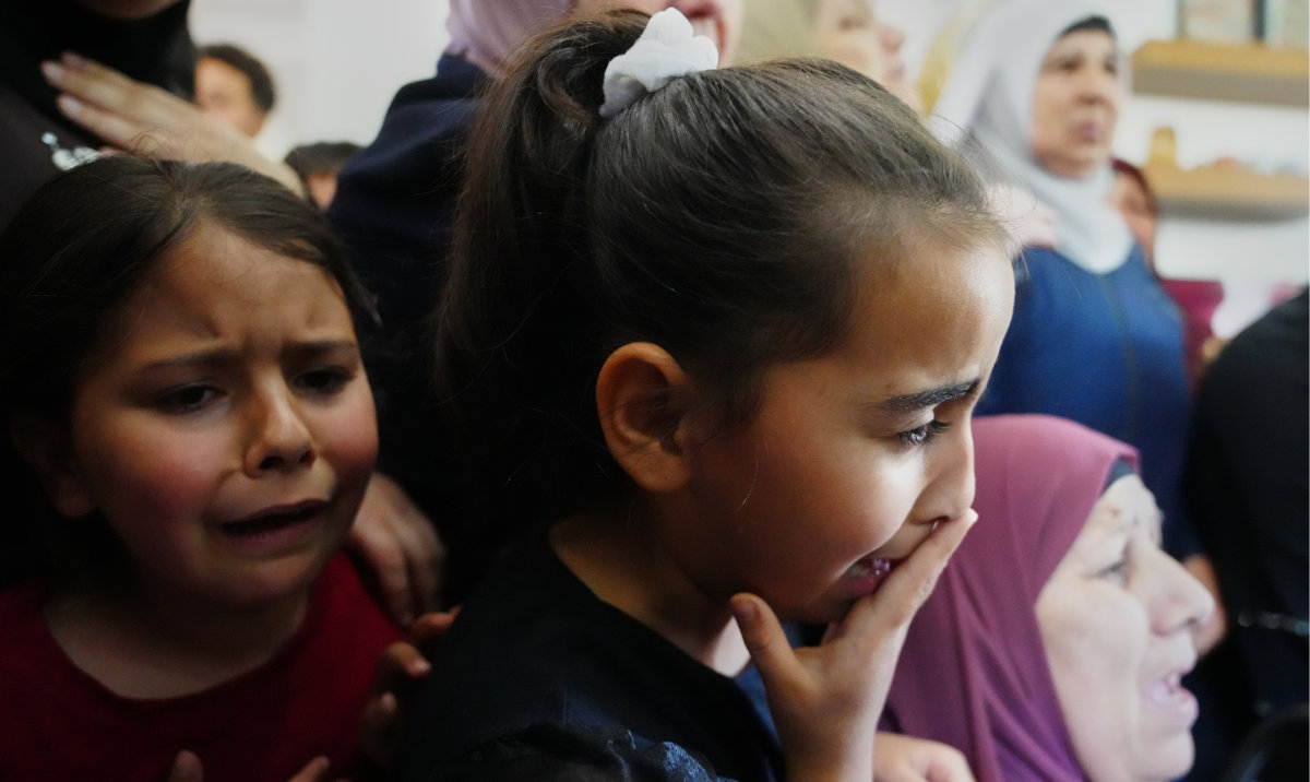 Children cry while they take the last look at the body of Palestinian Zakaria Qatousa, during his funeral on May 13. (AP)
