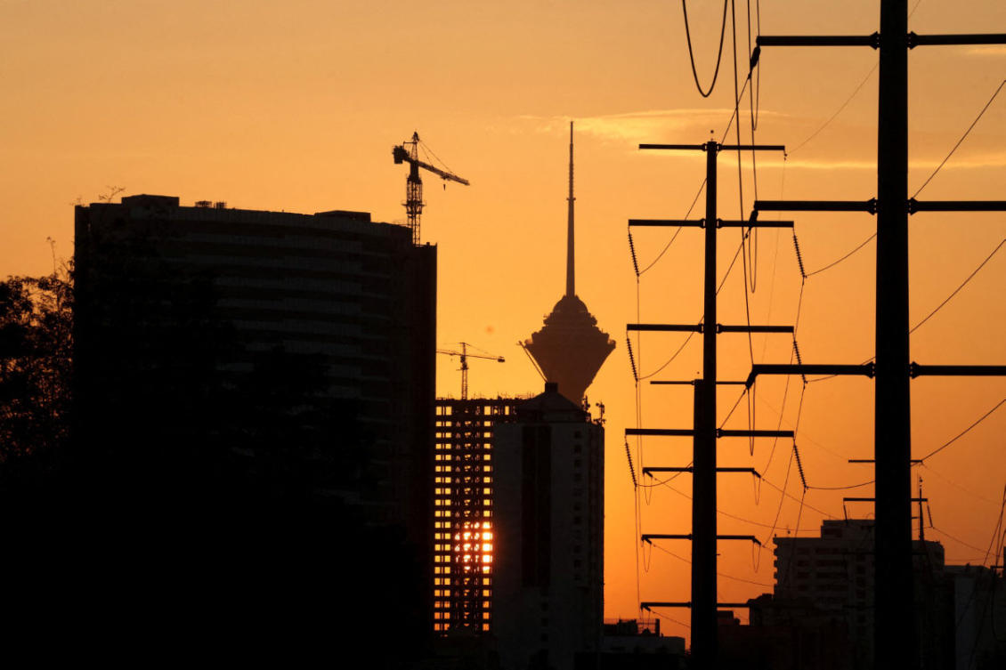 File photo showing the Milad Telecommunications Tower (C) and a row of electricity pylons in Tehran during sunset. (AFP file photo)