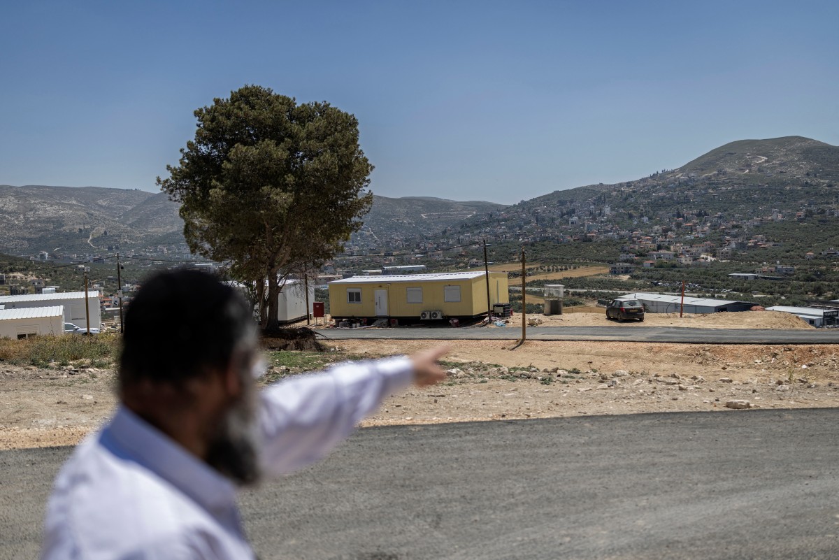 Israeli settler Meir Goldmintz gestures to the main road leading to the Sa-Nur settlement, south of Jenin in the Israeli-occupied West Bank, May 7, 2026. (Files / AFP)