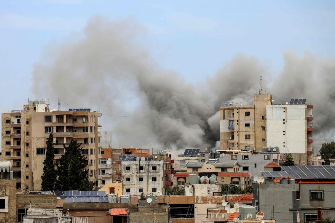 Smoke rises behind buildings following an Israeli airstrike in the southern city of Tyre on May 15, 2026. (AFP)