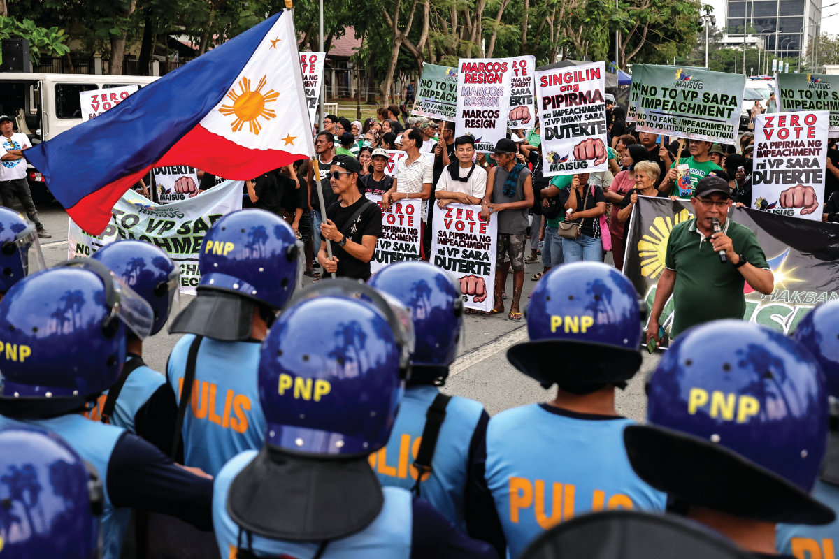 Philippine police block protesters supporting Vice President Sara Duterte outside the gates of the Senate. (AP)