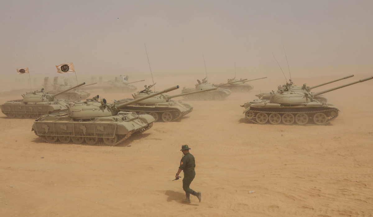 A Libyan soldier walks past tanks during the "Daraí al-Karama 2" military exercises, conducted by the Libyan National Army (LNA), under the command of Field Marshal Khalifa Haftar, in the Ras al-Alba region in southeastern Libya on May 16, 2026. (AFP)
