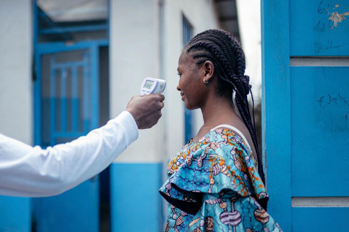 A staff member of the CBCA Virunga Hospital checks a visitor’s temperature using a a contactless infrared thermometer, before allowing her access to the hospital in Goma on May 17, 2026. (AFP)