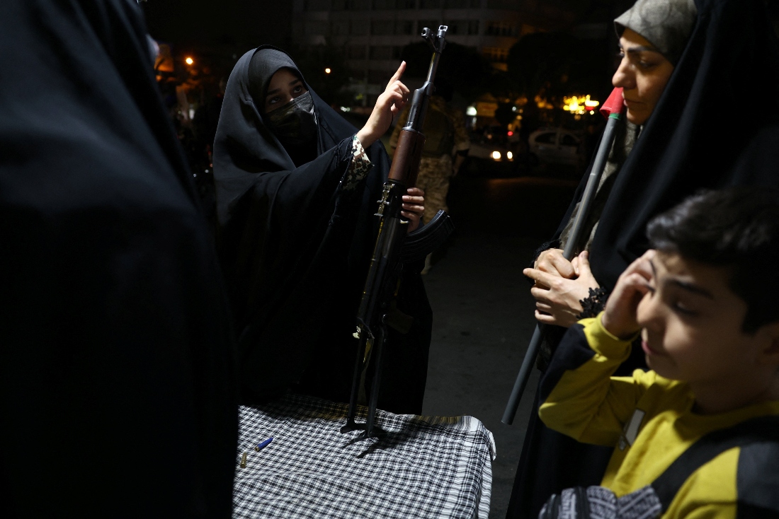 An Iranian military member educates women about how to use a gun at a booth in Hafte-Tir Square, in Tehran, Iran. (Wana News Agency)