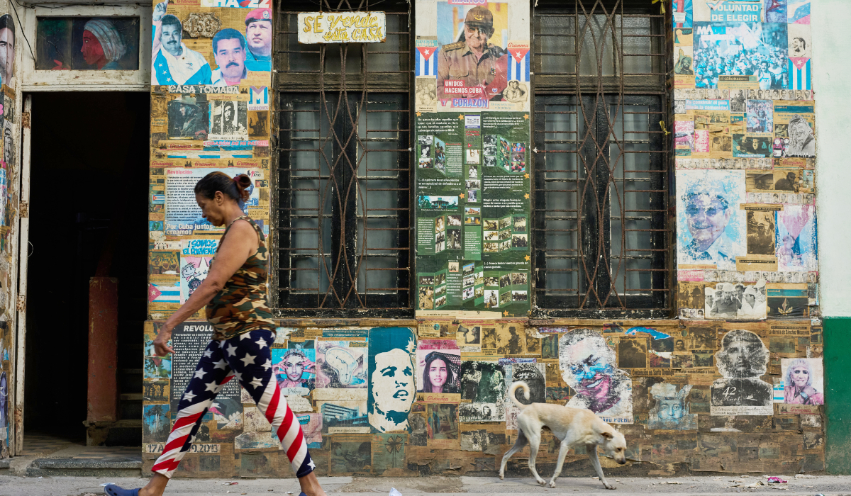 A woman wearing U.S. flag motif pants walks past a building that houses an art installation on the Cuban Revolution, featuring photos of former Cuban President Raul Castro and former Venezuelan President Nicolas Maduro, in Havana, Cuba, Tuesday, May 19, 2026. (AP)
