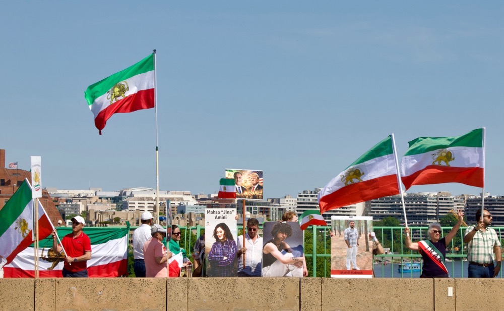 Demonstrators wave Iranian pre-Islamic revolution of 1979 flag on the Francis Scott Key Bridge during a rally in support of the Iranian people and to condemn the execution of political prisoners in Iran. (AFP/File)