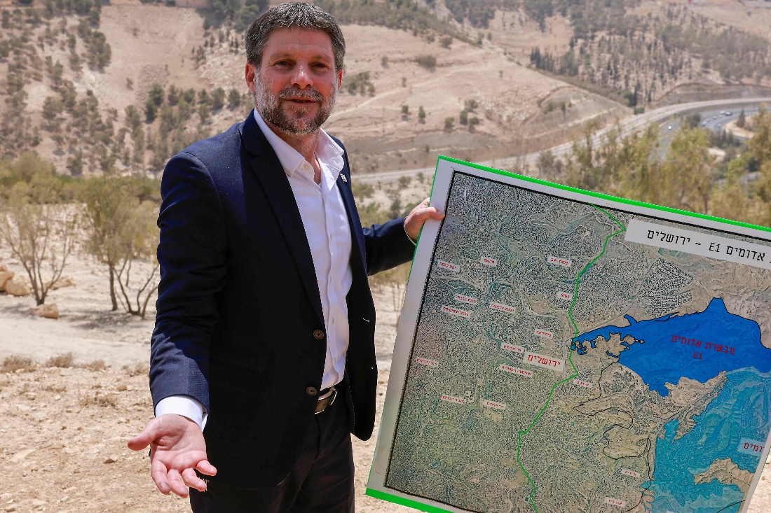 Israeli far-right Finance Minister Bezalel Smotrich holds a map of an area near the settlement of Maale Adumim, a land corridor known as E1, outside Jerusalem in the occupied West Bank. (AFP)
