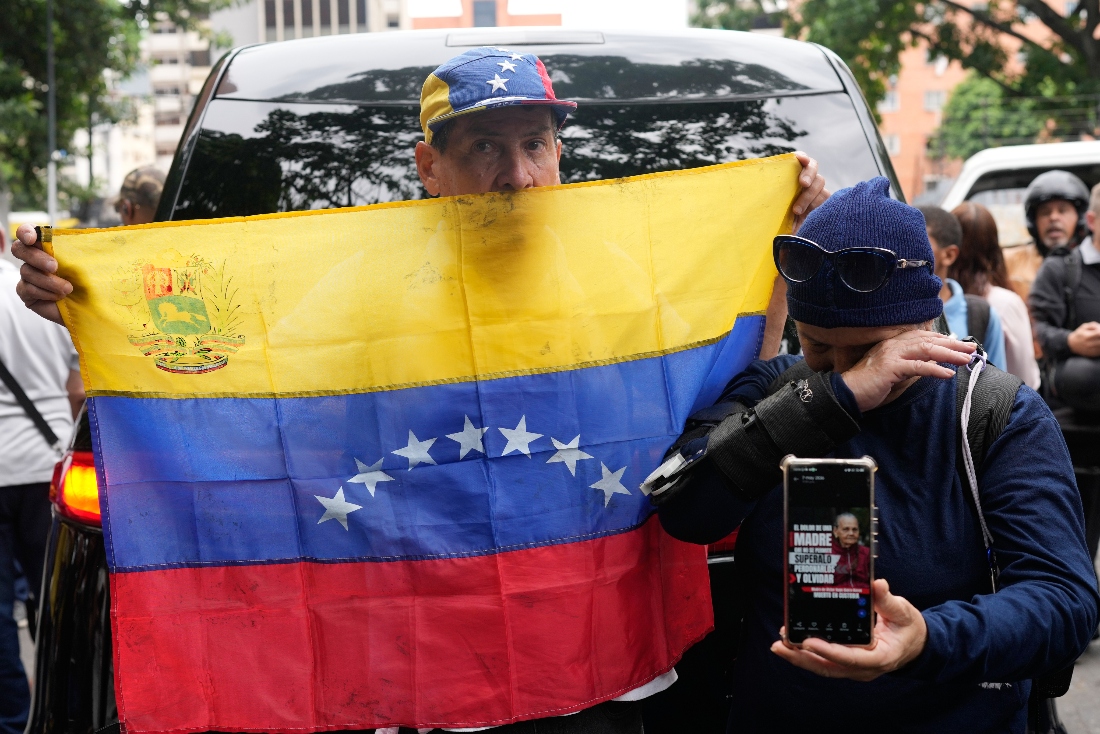A man holds up a Venezuelan flag during the wake of Carmen Navas, the mother of Victor Hugo Quero, who authorities said died in custody, in Caracas, Venezuela. (AP)