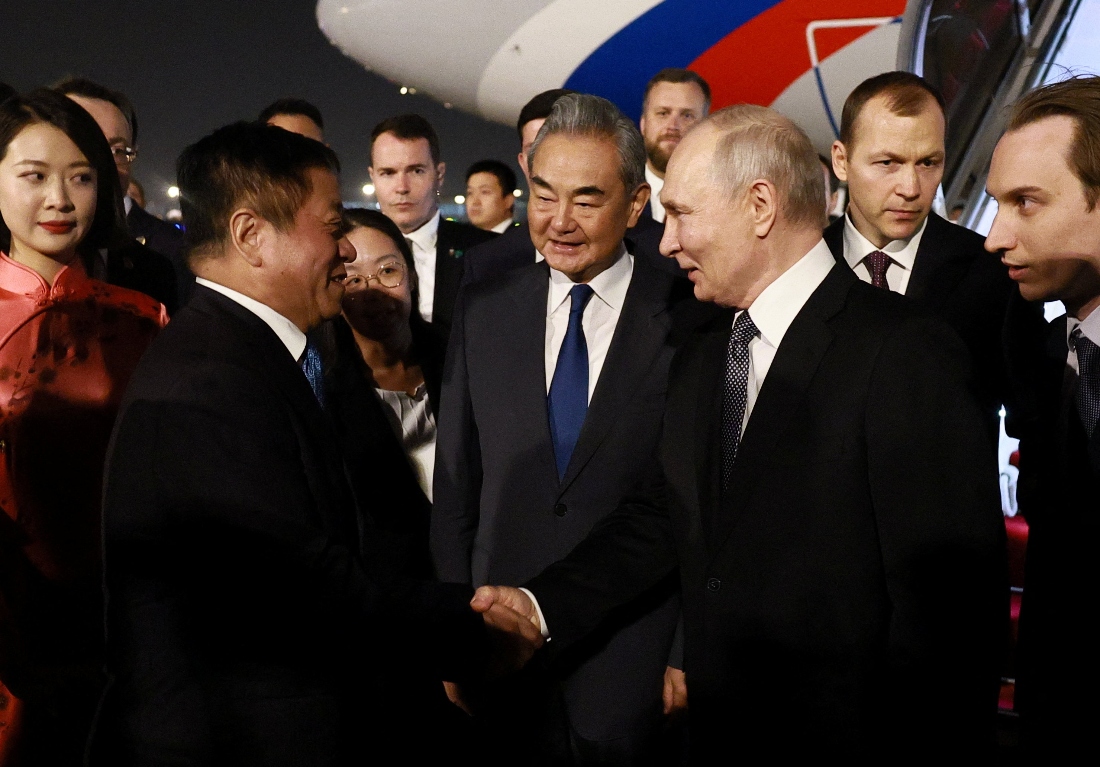 Russia's President Vladimir Putin shakes hands with China's Ambassador to Russia Zhang Hanhui as Foreign Minister Wang Yi stands nearby during a welcoming ceremony at an airport in Beijing, China. (Sputnik)