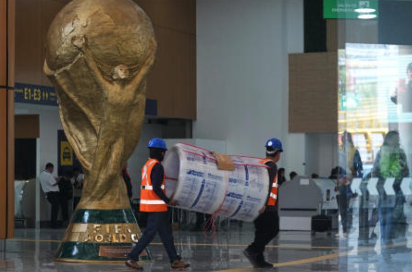 Workers transport a roll of foam next to the FIFA World Cup trophy during a guided media tour of the renovation site at Benito Juárez International Airport, in preparation for the 2026 World Cup, in Mexico City, on May 19, 2026. (AP)