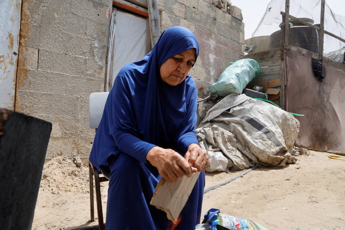 Palestinian Najia Abu Lehia sits outside her tent in Gaza as she speaks about her wish to perform Hajj amid Israeli travel restrictions. (Reuters)