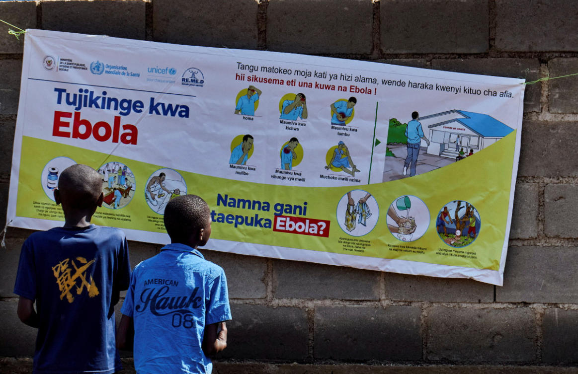 Congolese children Ibrah Asimwe and Alex Uketi read an advocacy poster as aid agencies intensify efforts to contain a new Ebola outbreak involving the Bundibugyo strain outbreak, in Bunia, Ituri province, Democratic Republic of Congo, on May 20, 2026. (Reuters/Gradel Muyisa Mumbere)