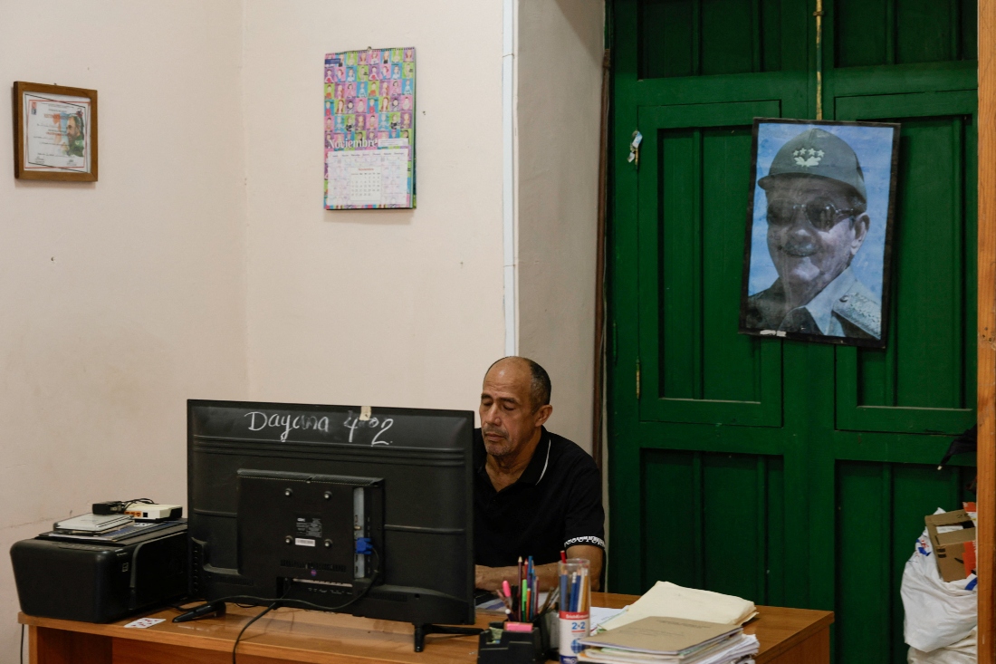 A man works in a school beside an image of former Cuban President Raul Castro in Havana, Cuba. (Reuters)