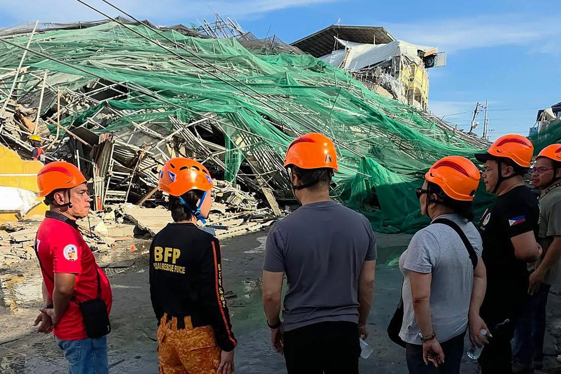 Above, rescuers stand next to a collapsed building in Angeles City in Pampanga province on May 24, 2026. (Angeles City Public Information Office/AFP)