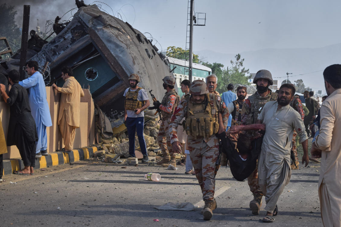Paramilitary soldiers and a volunteer carry an injured victim after recovering from an overturned train coach on a railway track at the site of bomb explosion, in Quetta, Pakistan on May 24, 2026. (AP)