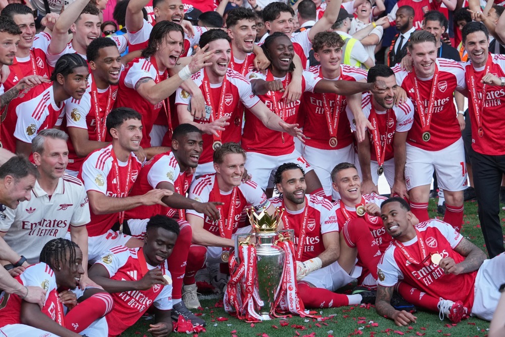 Arsenal players celebrate with the trophy after winning the Premier League title. (AP)