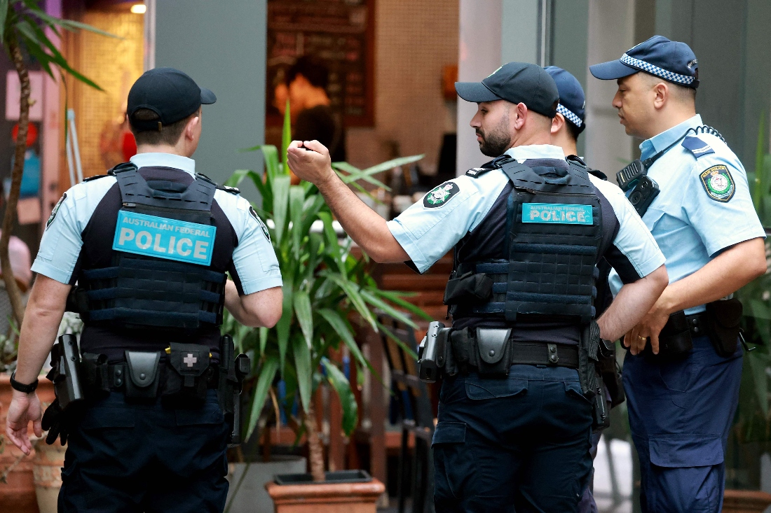 Australian Federal Police officers and New South Wales police officers stand outside the venue of the Royal Commission on Antisemitism and Social Cohesion in Sydney, Australia. (AFP)