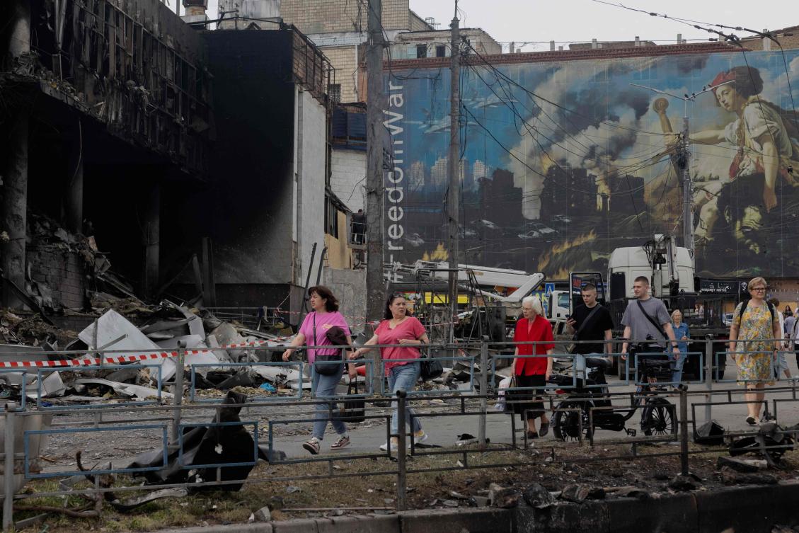 Local residents walk by a damaged shopping center following Russian strikes in Kyiv on May 25, 2026. (AFP)