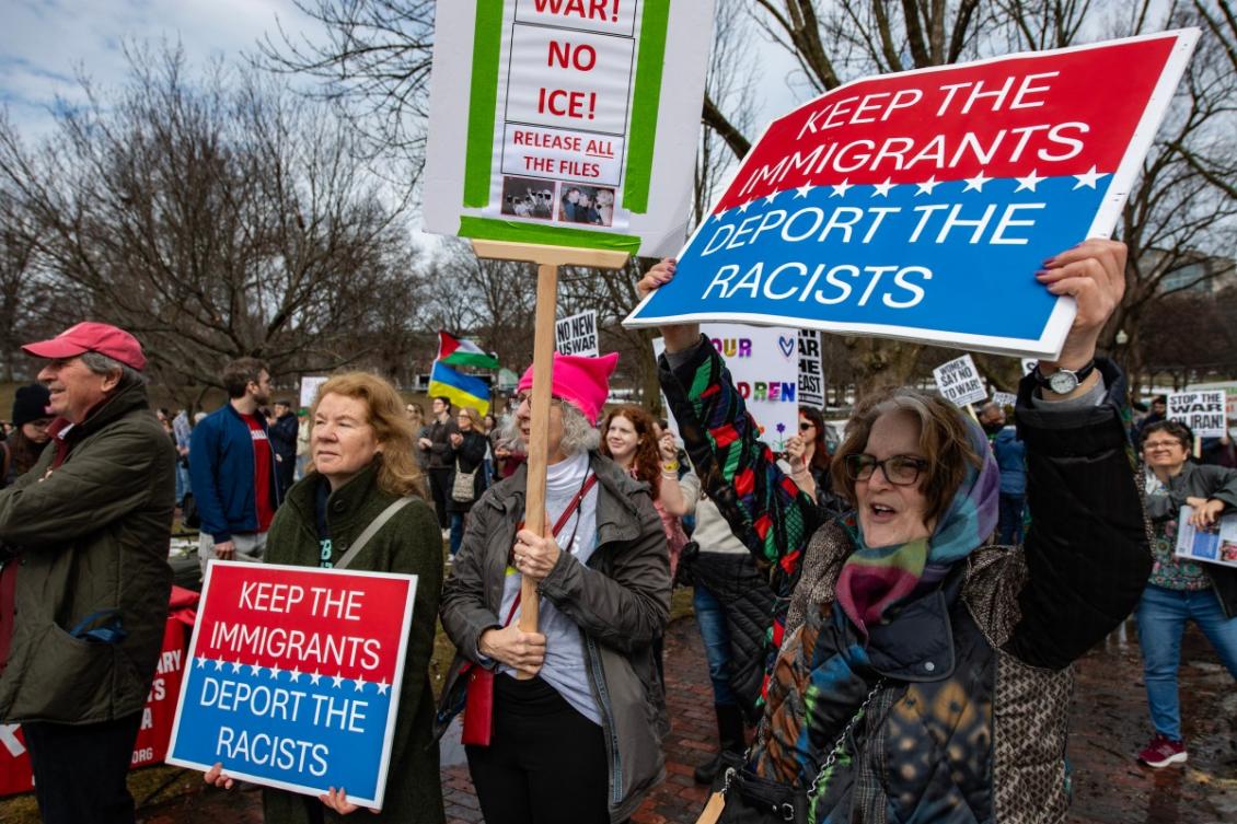 Demonstrators hold signs reading "Keep the Immigrants, Deport the Racists" during an International Women’s Day march against fascism on Boston Common in Boston, Massachusetts, on March 8, 2026. (AFP)