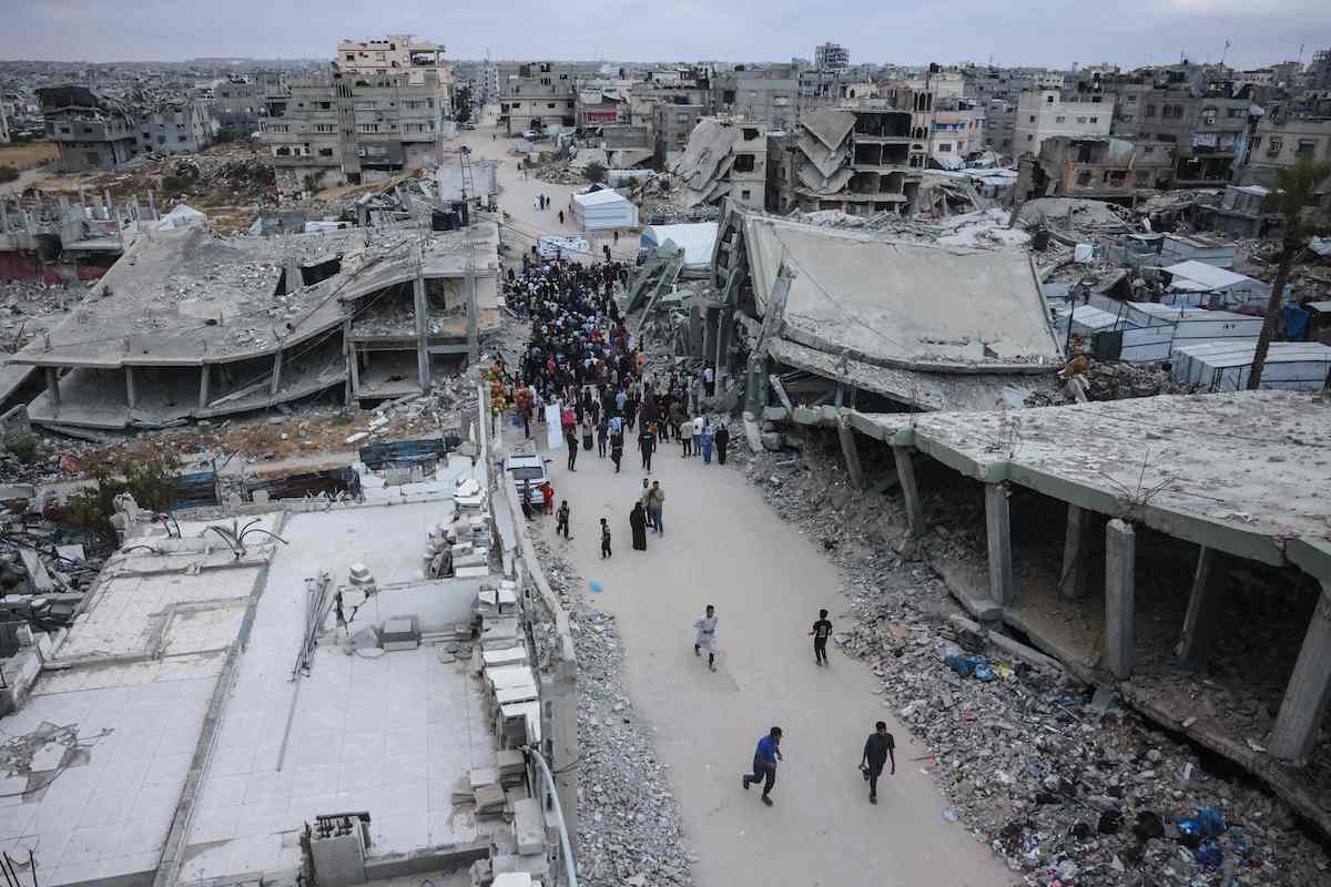 Palestinians gather on a heavily damaged street in Gaza to perform morning prayers marking the start of Eid Al-Adha. (AFP)