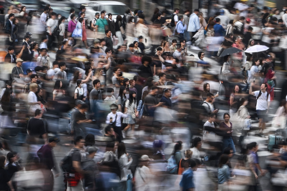 People walk across the street at Shibuya Crossing in Tokyo, Japan. (AFP)