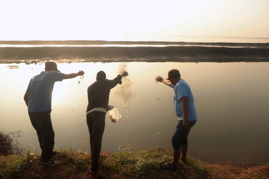 People scatter flowers to mark 20 years since a gas exploration accident triggered a mud flow that inundated more than a dozen villages in Sidoarjo, East Java, Indonesia. (AP)