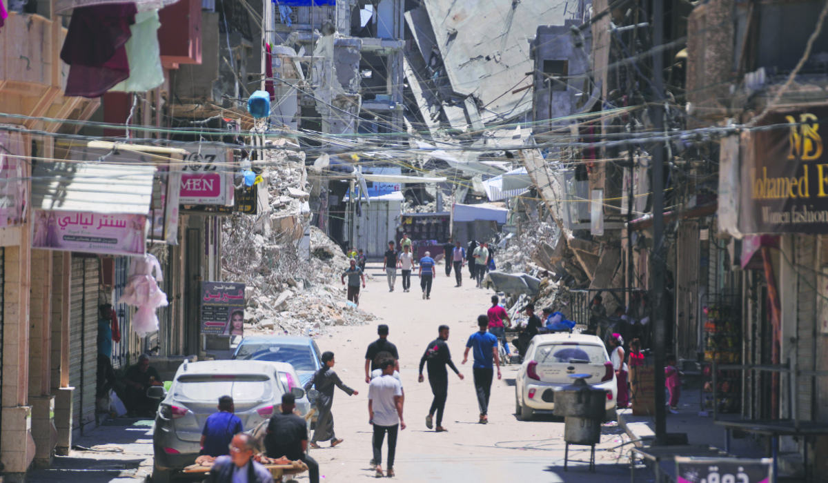 Palestinians walk along a street surrounded by buildings destroyed by Israeli military strikes during the Israel-Hamas war in Khan Younis, southern Gaza Strip, Friday, May 29, 2026. (AP)