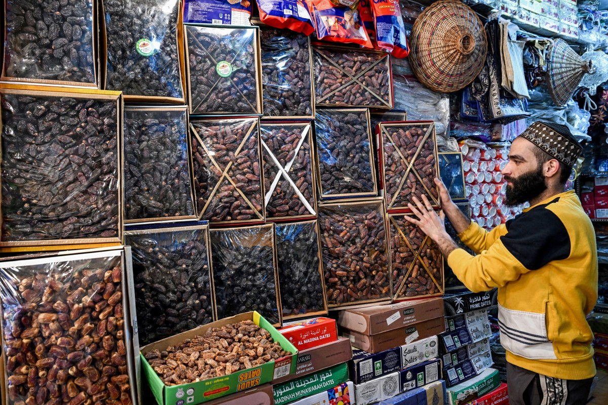 A shopkeeper arranges boxes of Saudi dates at a market in Srinagar, Indian-controlled Kashmir, on Feb. 17, 2026. (AFP/File)