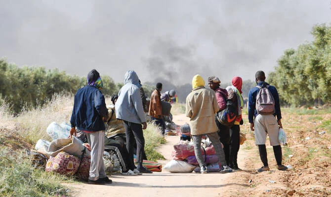 Migrants leave from a camp for undocumented migrants at Al-Amra on the outskirts of Tunisian port city of Sfax. (AFP)