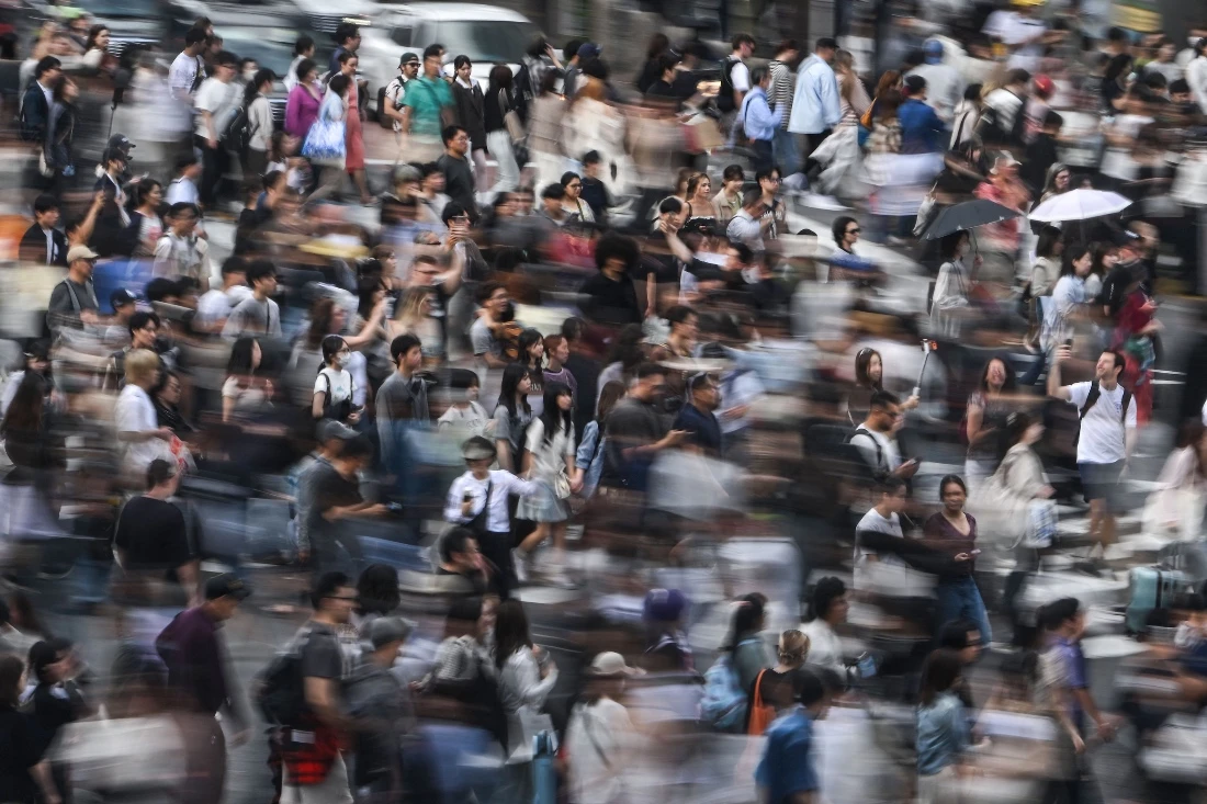 People walk across the street at Shibuya Crossing in Tokyo, Japan. (AFP)