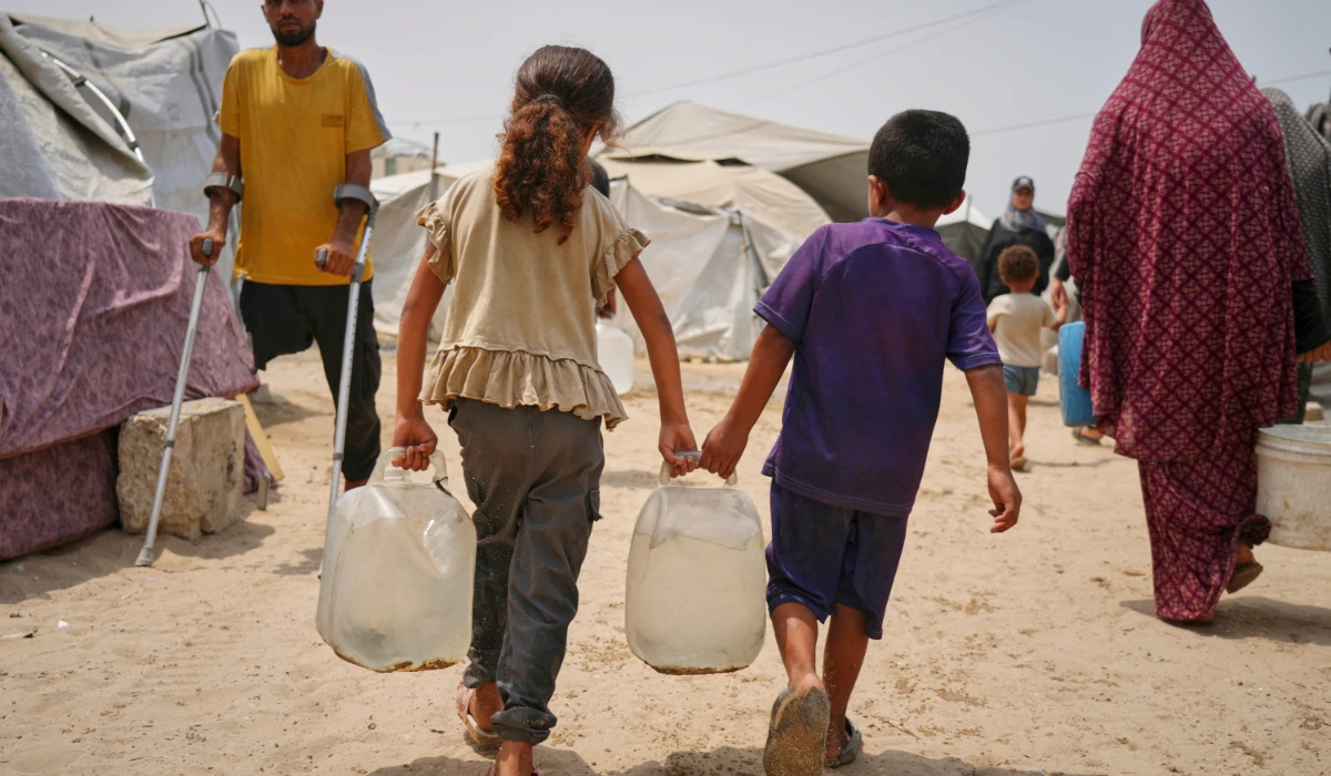 Palestinian children haul jerrycans of water collected from a distribution point in Gaza City. (AP)