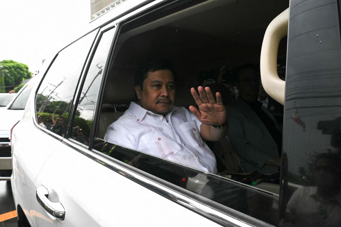 Philippine Senator Jose Jinggoy Estrada waves to photographers from inside his car as he heads to the national police headquarters to surrender on June 1, 2026. (AFP)