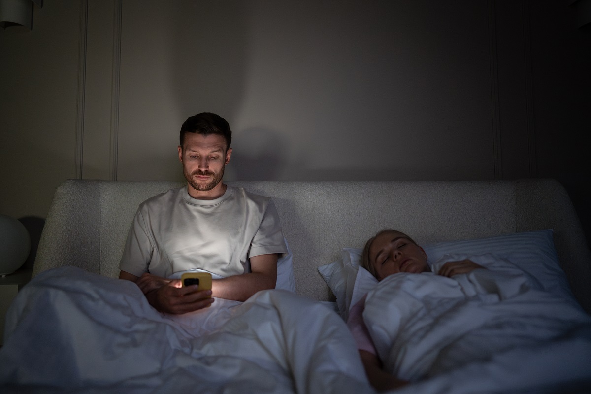 An illustrative image of a sleep-deprived man scrolling on social media. (Shutterstock)