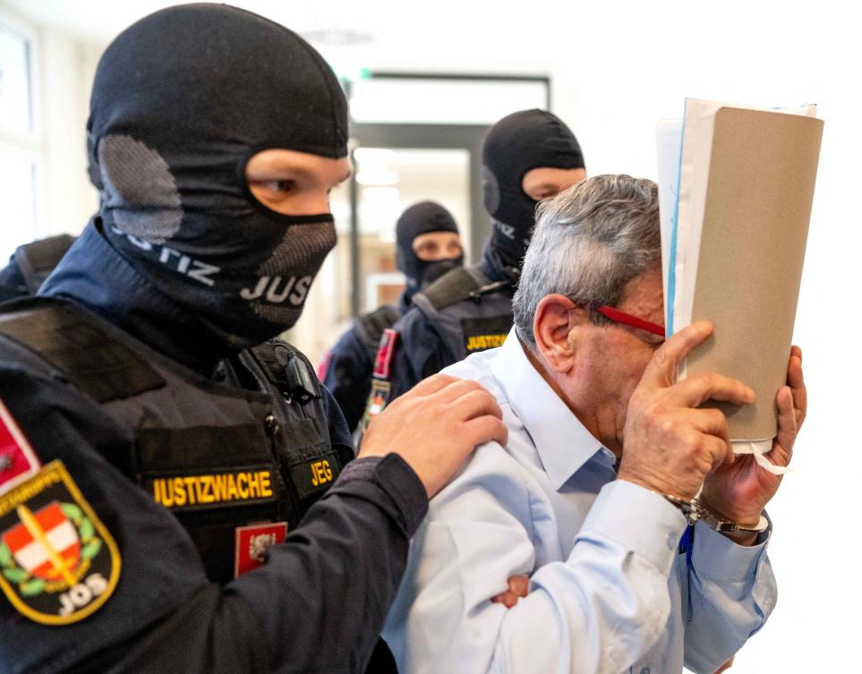 An ex-Syrian general accused of torturing opponents of Bashar Assad is escorted in handcuffs at the Regional Vienna’s Court of Austria on Monday. (AFP)