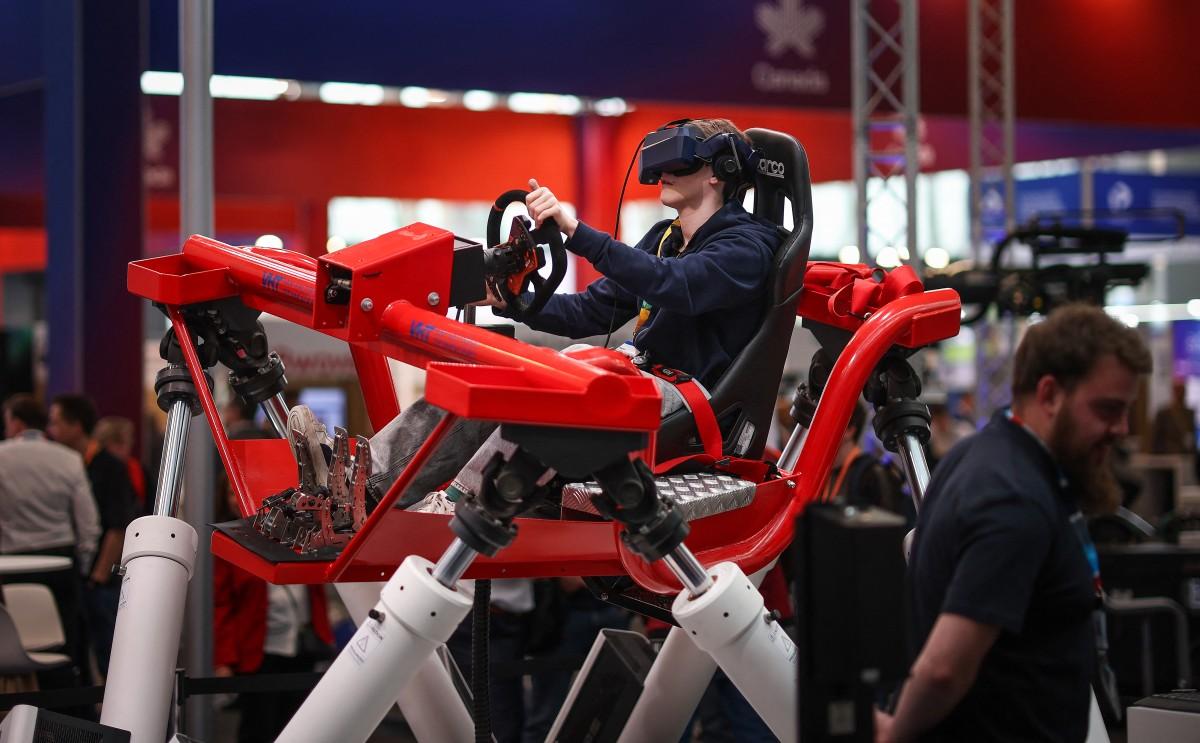 A visitor uses a pneumatic driving simulator at the booth of Bosch Rexroth during the Hannover industrial trade fair for mechanical and electrical engineering and digital industries, in Hannover, northern Germany on April 20, 2026. (File/AFP)