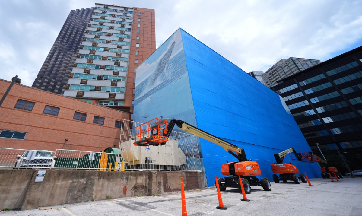 A section of a mural, known as the "Whaling Wall 82," created by artist Wyland, is visible as part of it on the right side of the building was painted over, Monday, May 18, 2026, in Dallas. (AP)