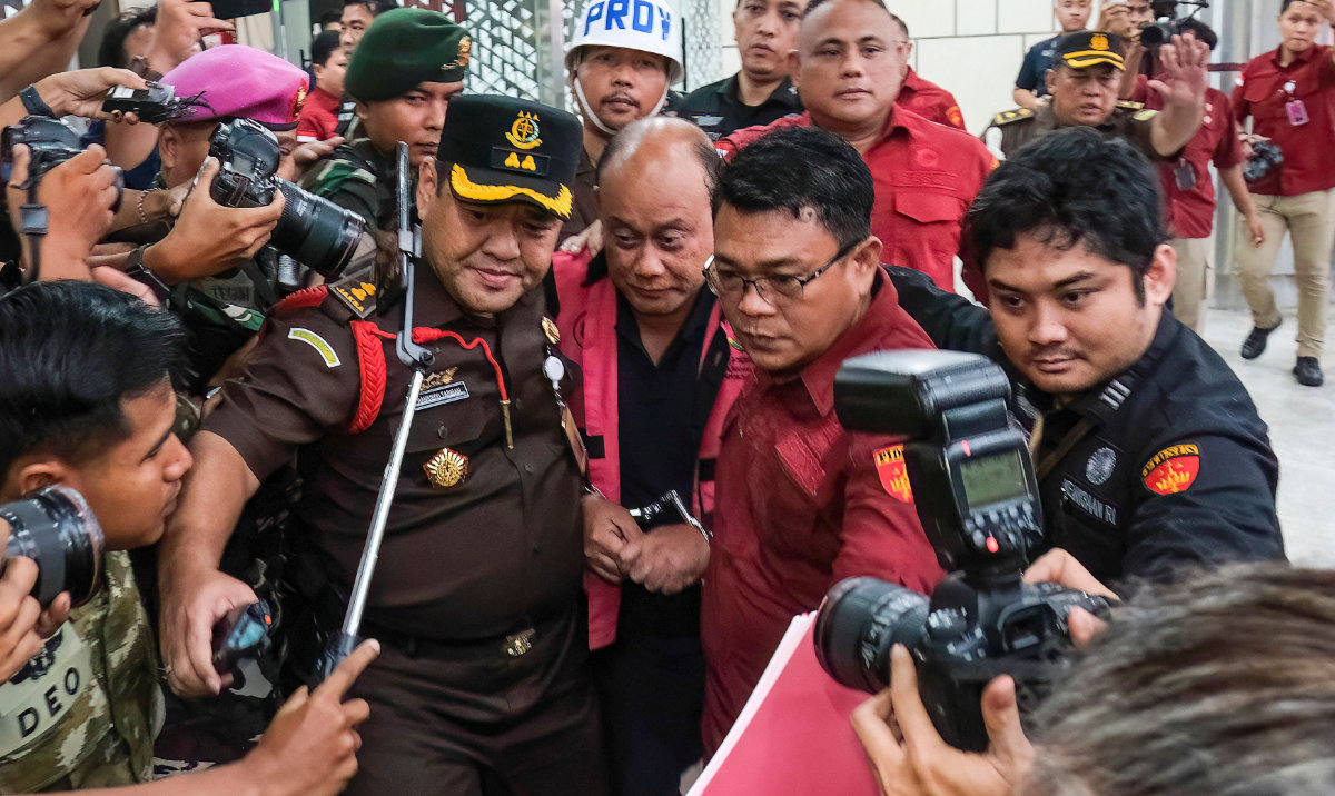 Dadan Hindayana, former head of Indonesia’s free school meals program, is escorted by officers and military personnel in Jakarta on Wednesday. (AFP)
