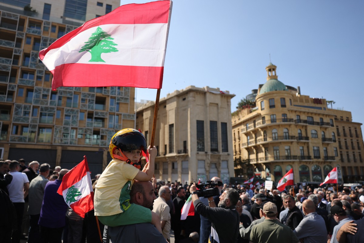 A child waves a Lebanese flag while residents of the devastated southern Lebanese border villages protest against the destruction of their villages and being prevented from returning by order of the Israeli army, at Martyrs’ Square in central Beirut, Lebanon. (AFP)