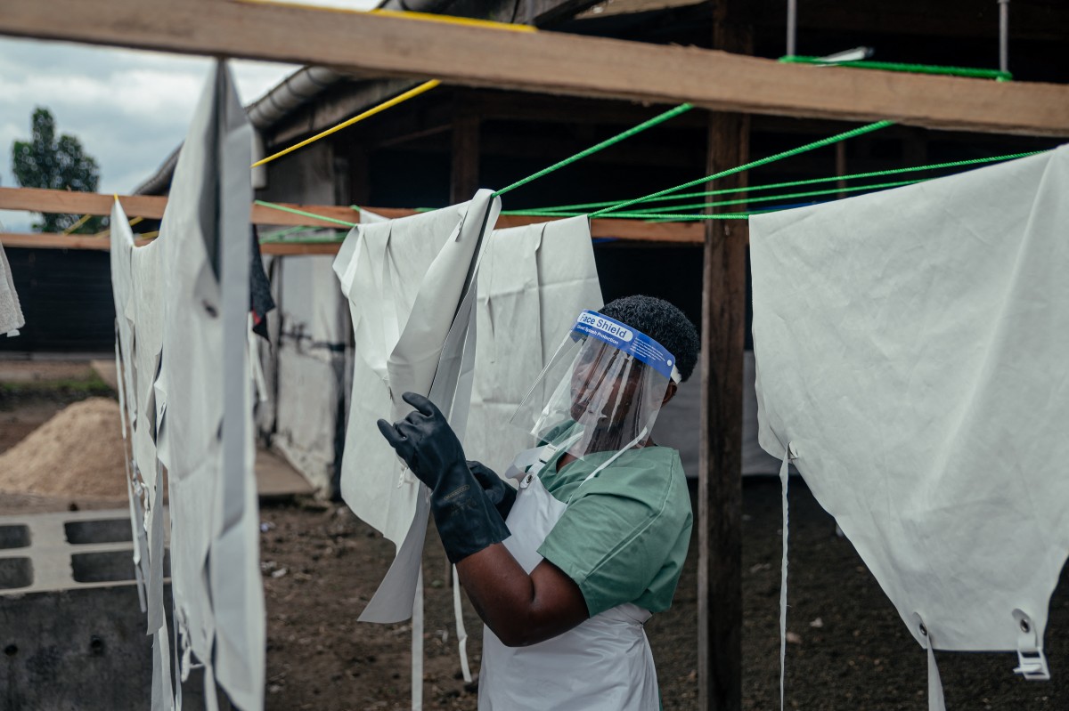A staff member hangs up protective equipment to dry after washing them at the Ebola Treatment Center (ETC) in Munigi, DR Congo. (AFP)