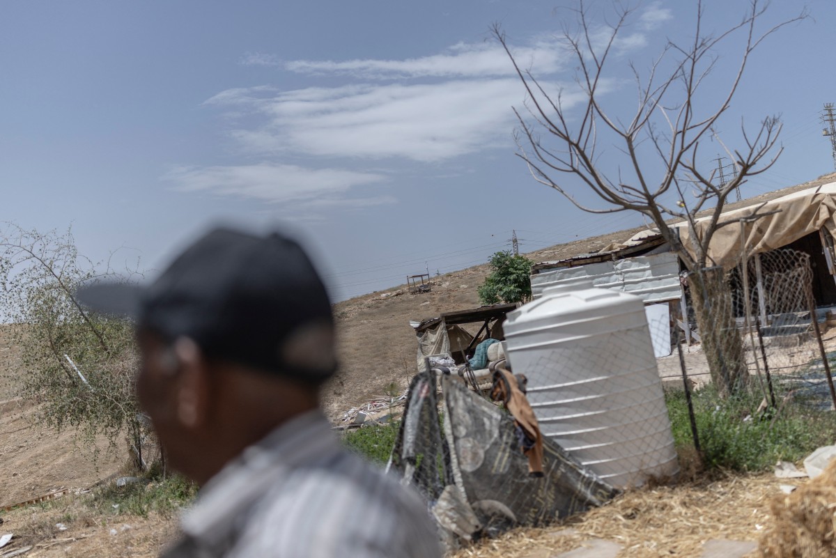 A man stands near a water tank in the Bedouin community of Khan al-Ahmar in the occupied West Bank, May 20, 2026. (AFP)