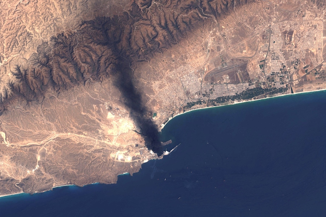 A handout satellite image from Landsat-8/9, made available by the US Geological Survey on March 17, 2026, shows smoke billowing from the Mina Petroleum facility at Salalah Port in Oman on March 16, 2026. (AFP)