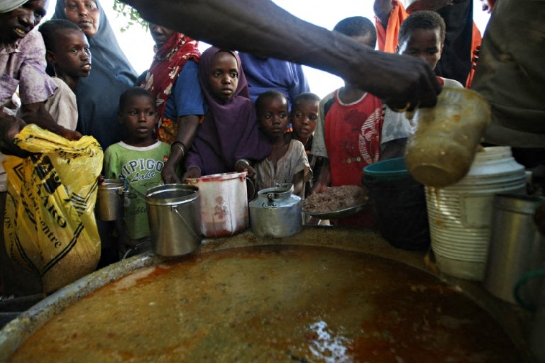 Internally displaced children line up to receive a food ration at a food distribution point at a voluntary centre in Mogadishu, Somalia. (AFP)