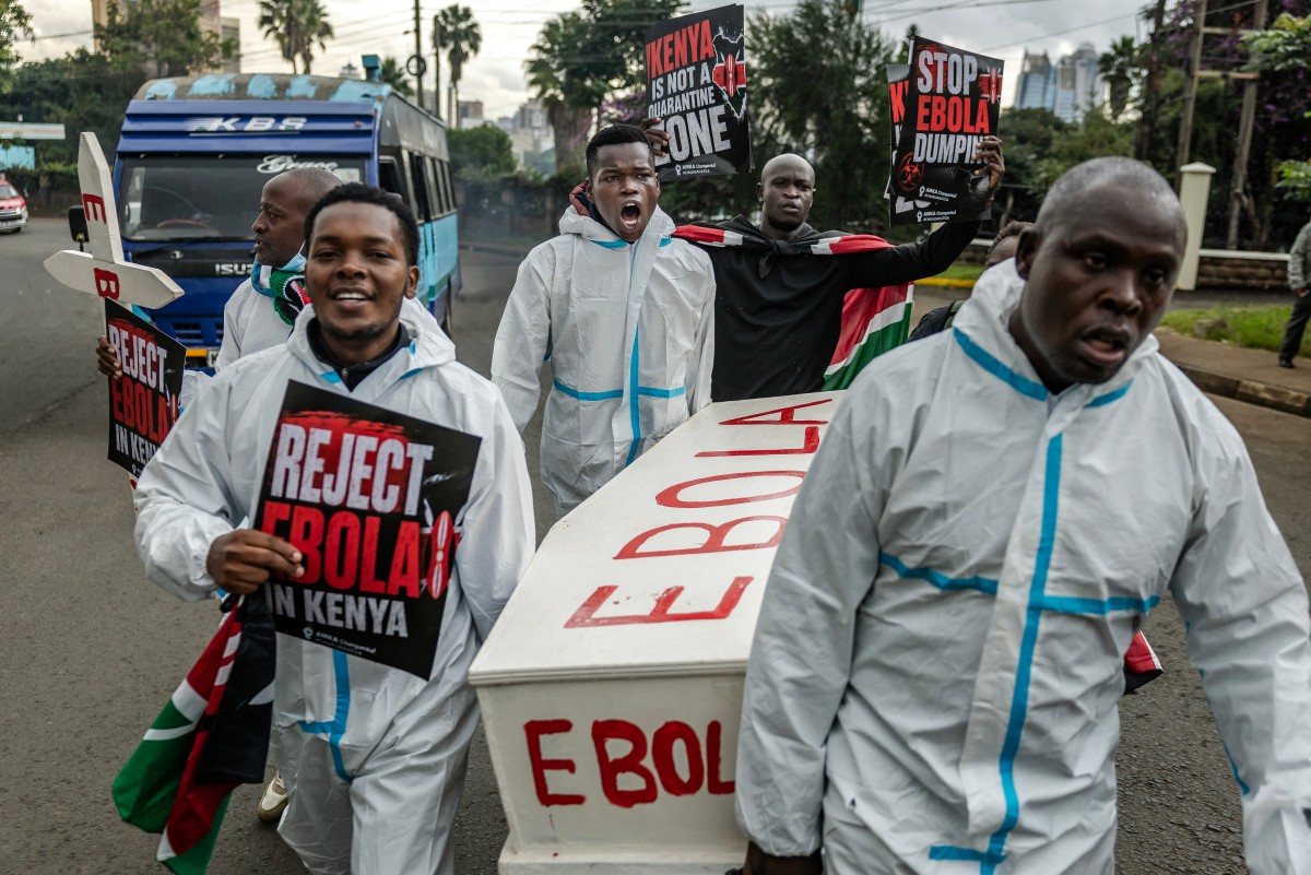 Activists chant slogans as they carry placards and a mock coffin during a protest against a US-built Ebola quarantine centre planned to begin operations at Kenya's Laikipia Air Base, in Nairobi, Kenya. (AFP)