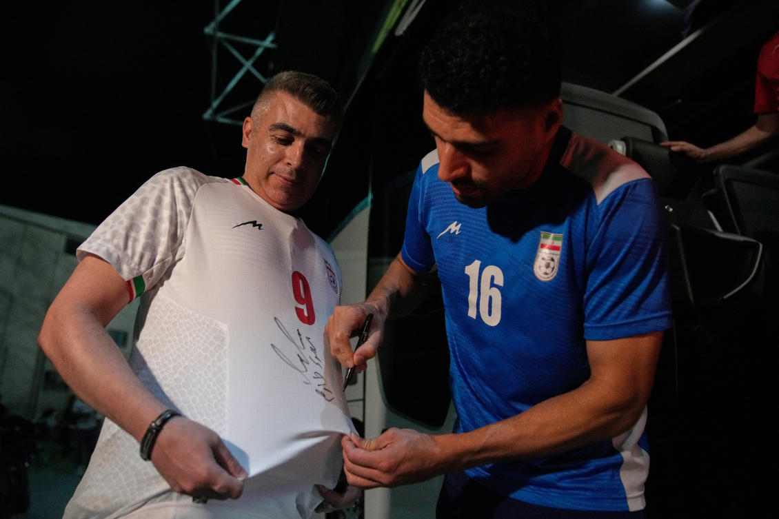 Iran's Mehdi Torabi signs a fans jersey after a friendly match between Iran and Mali, in Antalya, southern Turkiye, on Thursday. (AP)