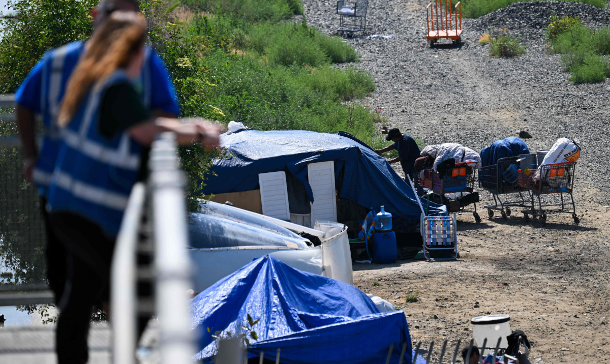 Outreach workers with Hope The Mission look toward a homeless encampment in the Panorama City neighborhood of Los Angeles, California on June 1, 2026. (AFP)