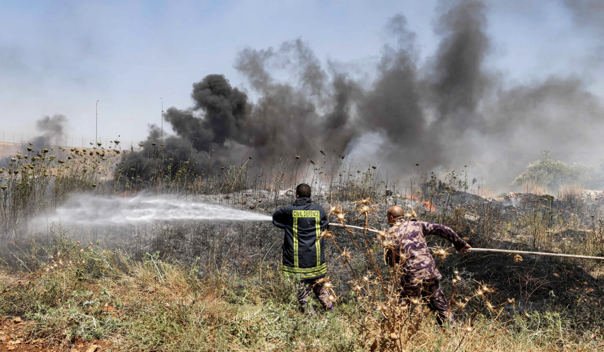 Civil defence forces and volunteers attempt to extinguish a fire in a field in the Palestinian town of Huwara in the occupied West Bank on June 6, 2026, after a reported arson attack by Israeli settlers according to local officials. (AFP)