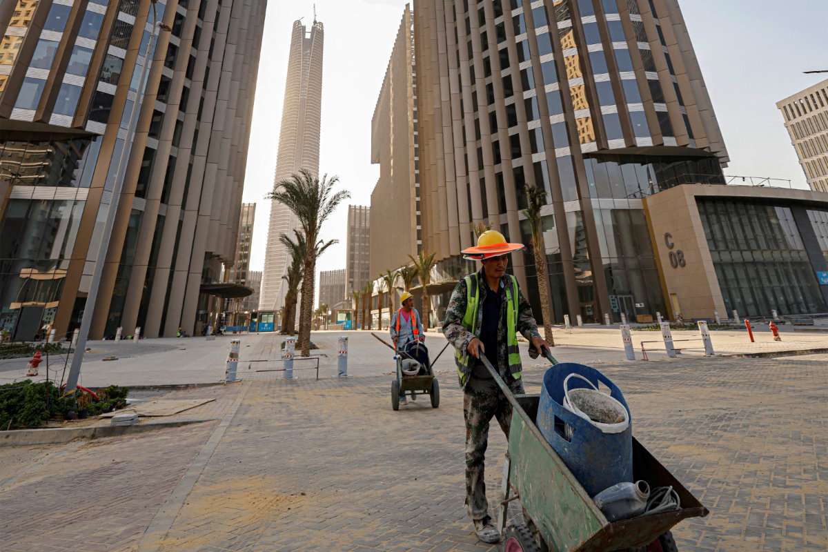 This photo taken on August 1, 2023, shows Chinese construction workers at work at the business and finance district in Egypt's New Administrative Capital megaproject, about 45 km east of Cairo. In the background is the Iconic Tower skyscraper. (AFP)