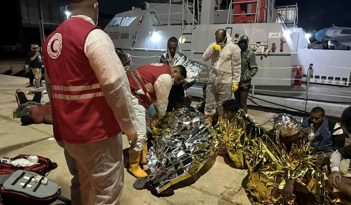 Red Crescent workers tend to rescued migrants sitting at dock with thermal blankets, after two boats carrying migrants capsized off the Libyan coastal city of Al Khums causing multiple casualties, in a location given as Khums, Libya, November 15, 2025. (REUTERS)