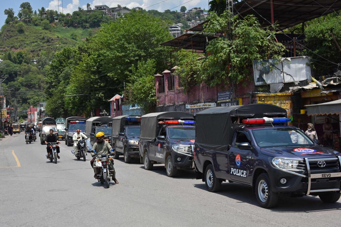 Commuters ride past security personnel as they patrol a street ahead of a protest by the Joint Awami Action Committee (JAAC) in Muzaffarabad, capital of Pakistan-administered Kashmir on June 7, 2026. (AFP)